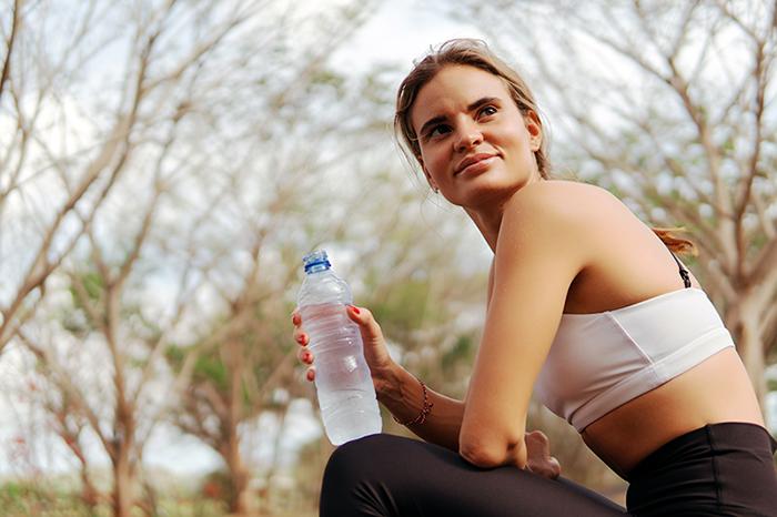 A woman sitting with a water bottle