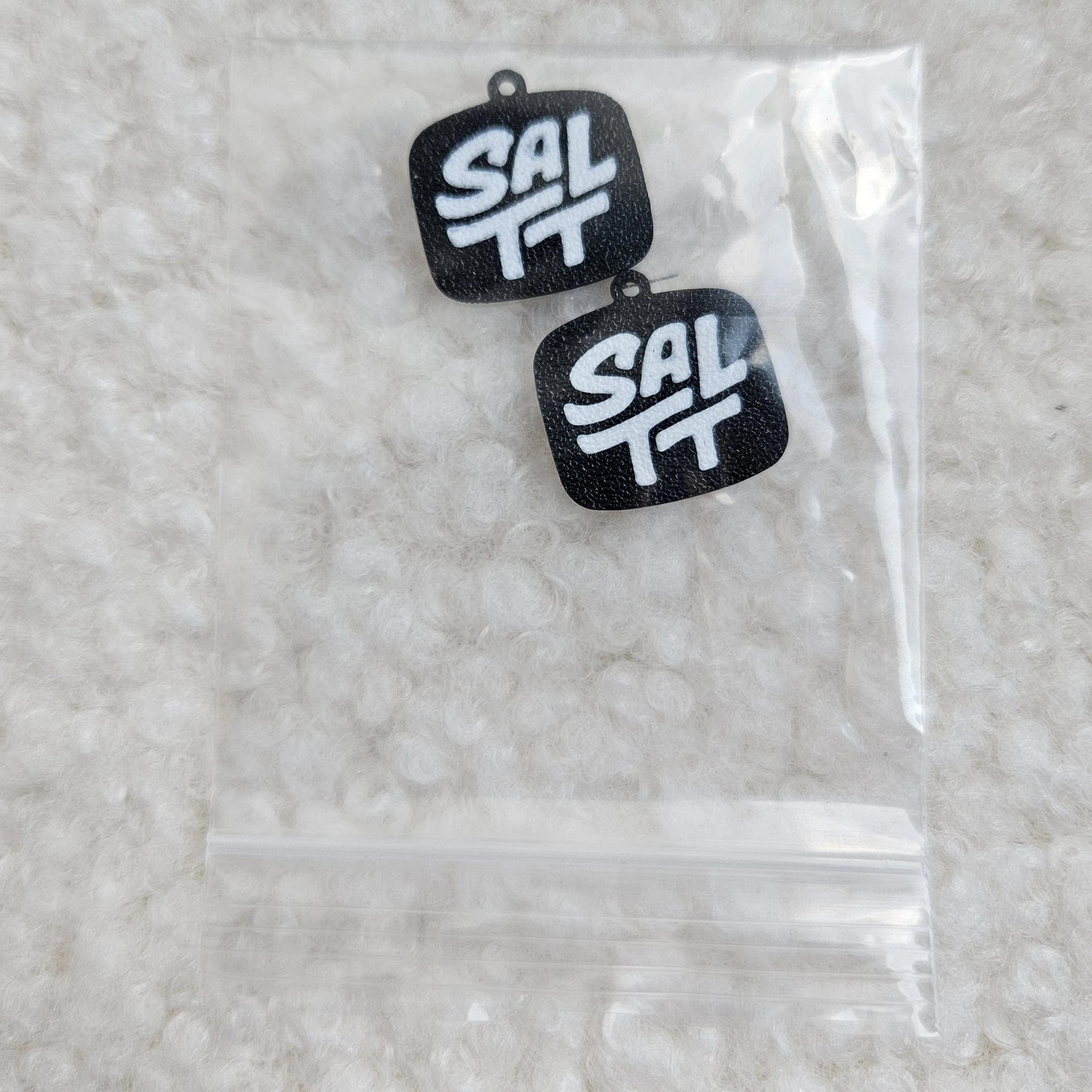 close up of SALTT logo charms