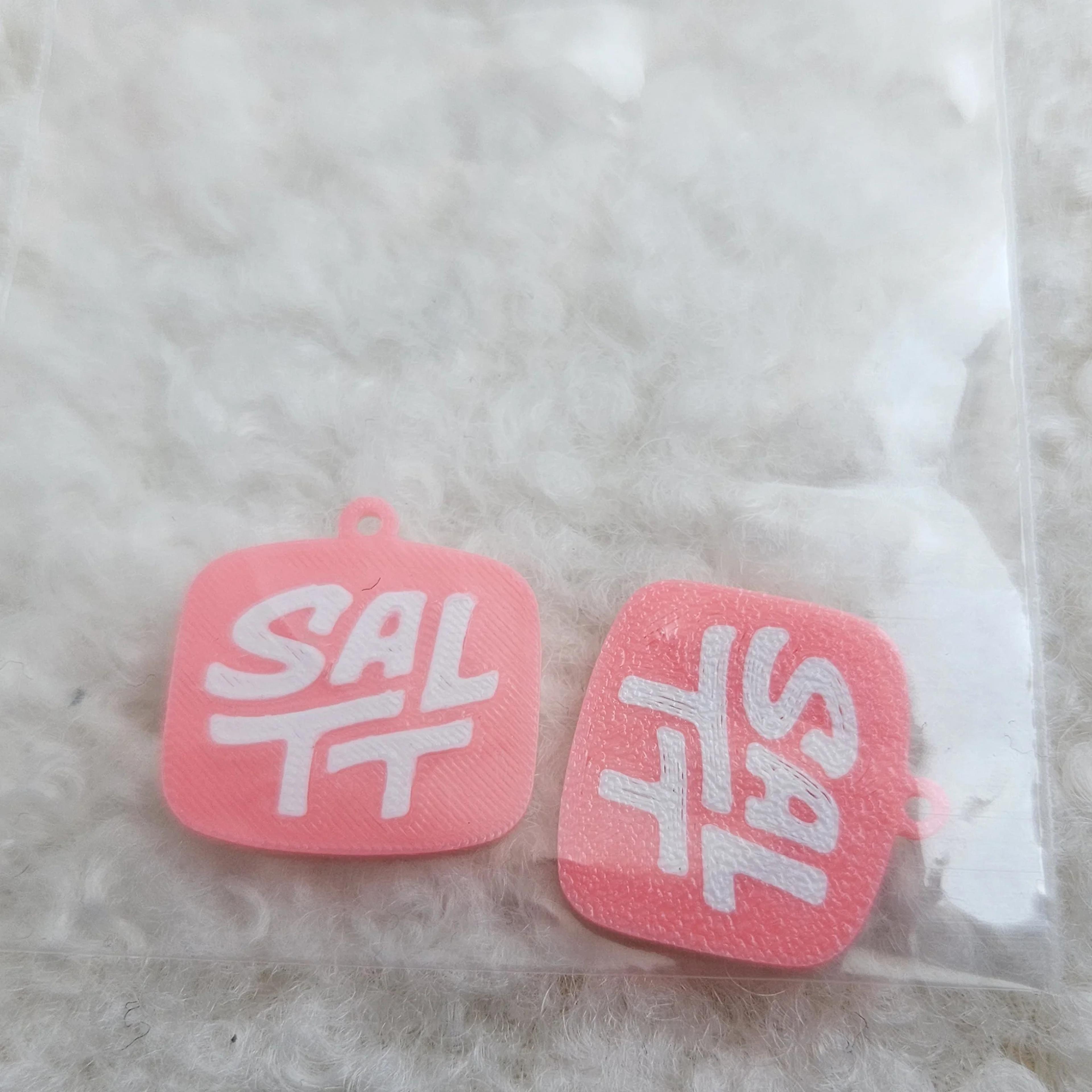 pink SALTT logo charms