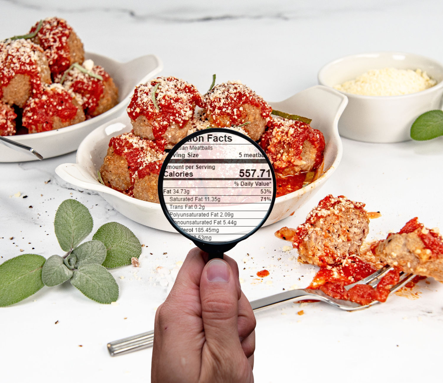 Hand with magnifying glass in front of meatballs