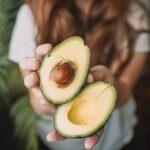 woman holding avocados