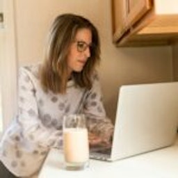 woman working with a glass of milk nearby