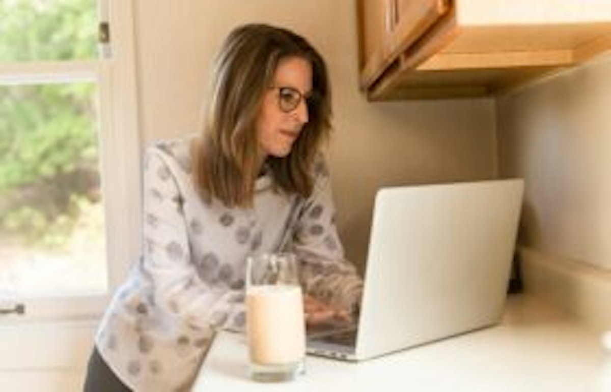 woman working with a glass of milk nearby