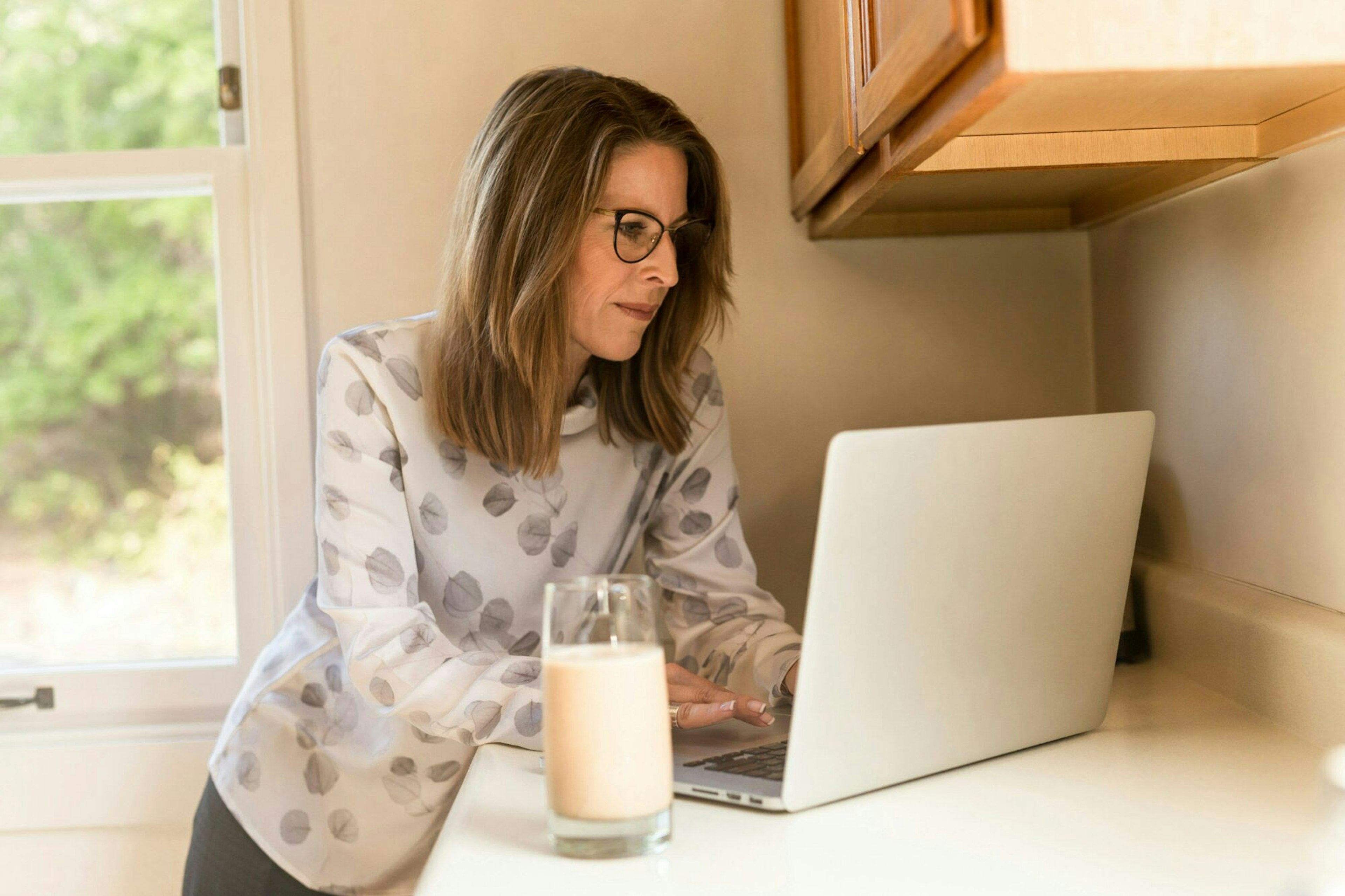 woman working with a glass of milk nearby