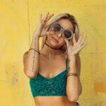 woman holding up sunglasses