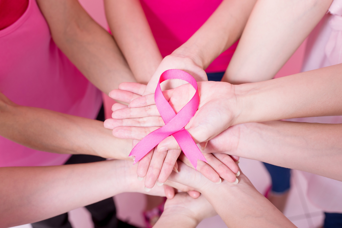 people holding up pink ribbon representing cancer